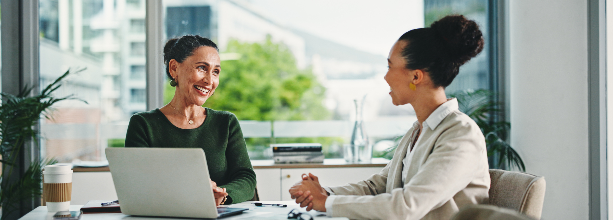 Laptop, discussion and business women in office with feedback on corporate performance review. Meeting, computer and female hr manager with employee for advice on career evaluation in workplace